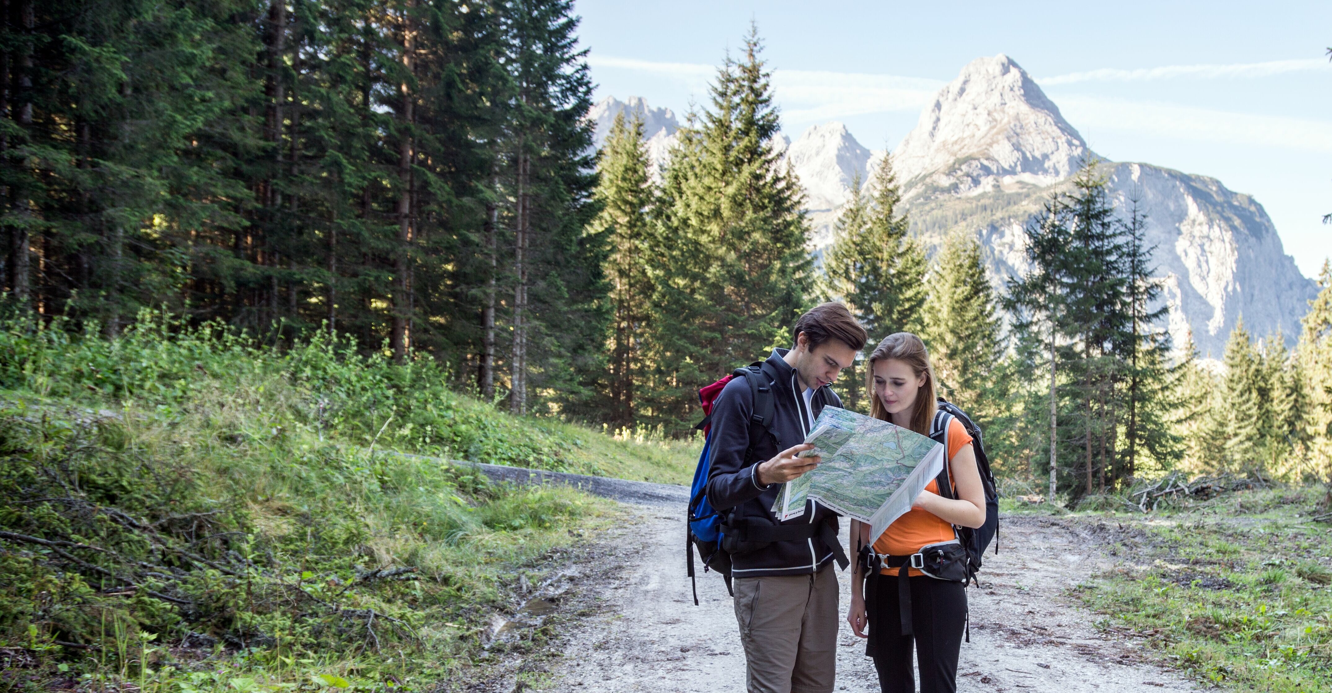 Zwei Wanderer unterhalten sich mithilfe einer Karte über den Weg